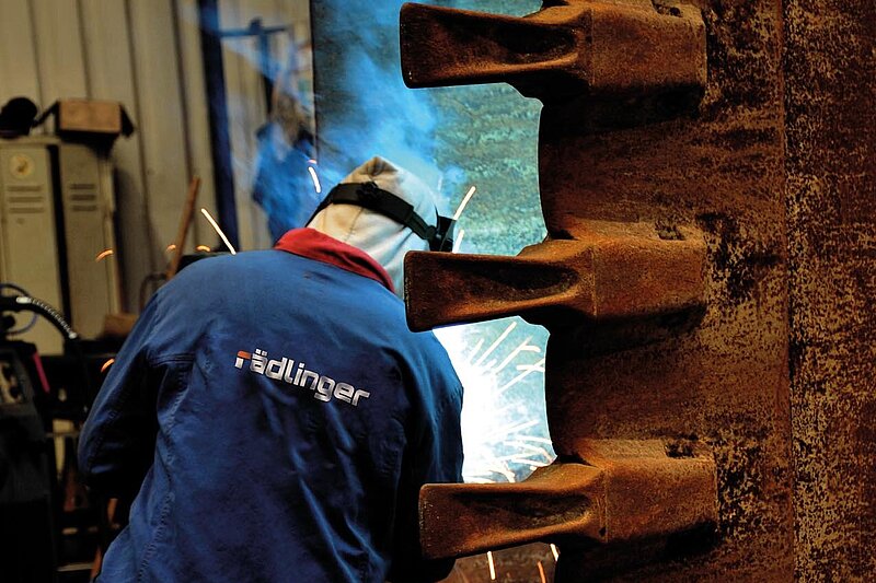 Welding work on an excavator bucket for regeneration and repair at Rädlinger